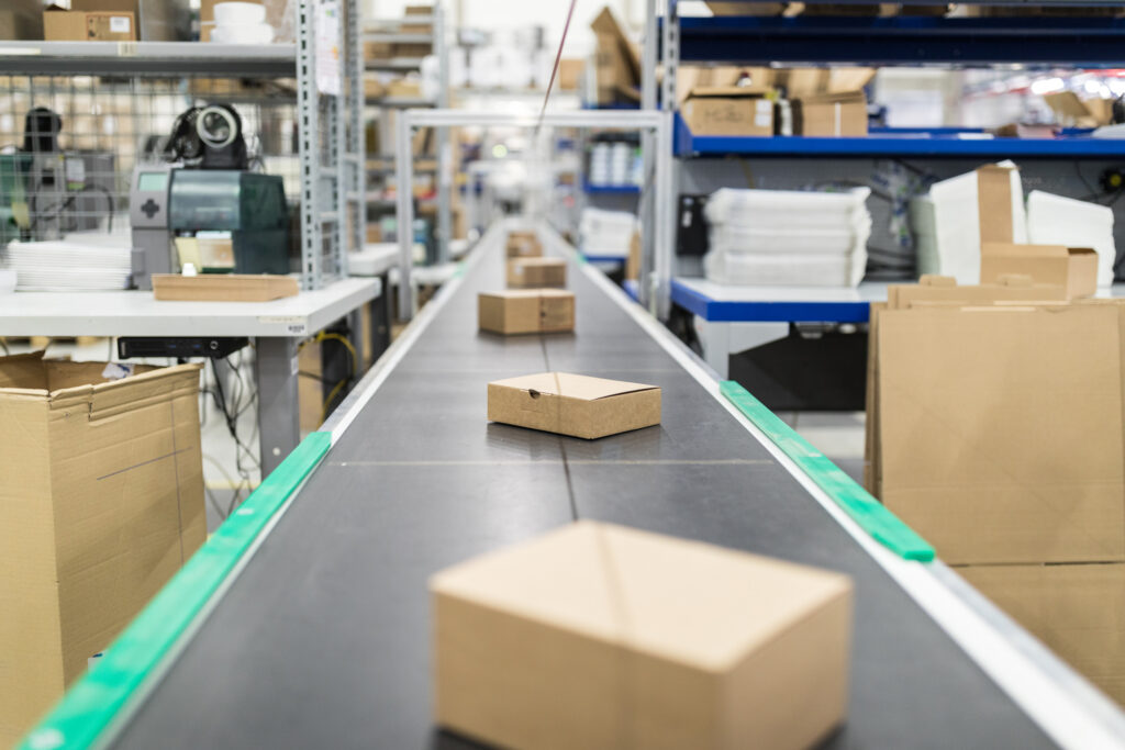 Folded cartons moving along a conveyor belt on a packaging line